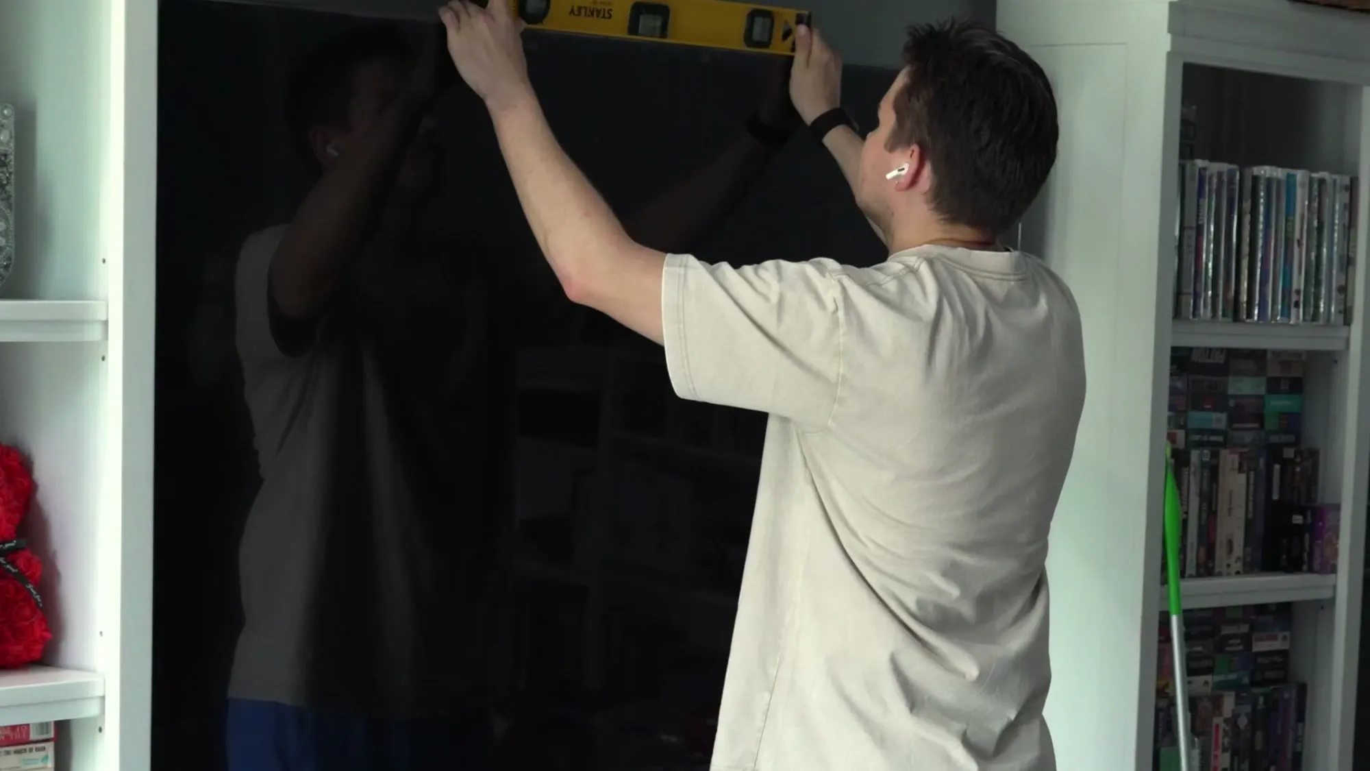 Installer levelling a large wall-mounted TV